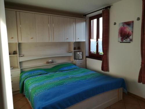 una camera da letto con un letto con lenzuola blu e una finestra di Casa Olivo a Montagnola