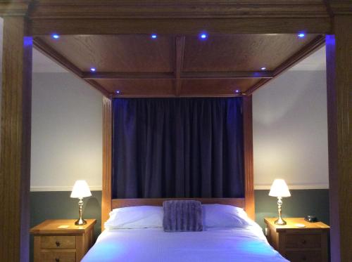 a bedroom with a canopy bed with blue lights on it at Hillview Park in Beauly