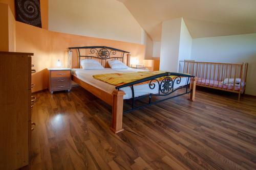 a bedroom with a large bed with a wooden floor at Villa Bodiky in Bodíky