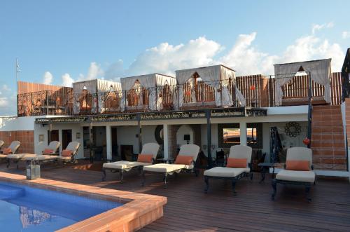 a deck with lounge chairs and a swimming pool at La Pasion Colonial Hotel Boutique By Bunik in Playa del Carmen
