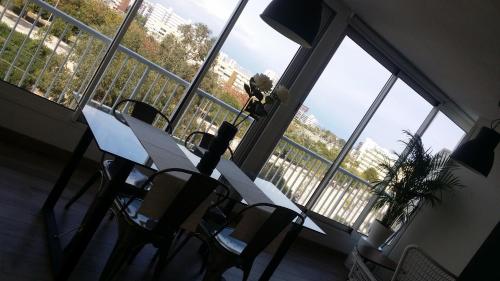 アリカンテにあるParkview near beachの大きな窓のある客室で、テーブルと椅子が備わります。