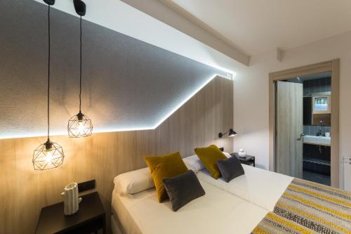 a bedroom with a large bed with yellow pillows at Hotel Onyarbi in Hondarribia