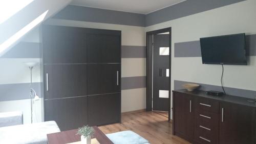 a living room with a large wall with a tv at Apartamenty Ostryga Łeba in Łeba
