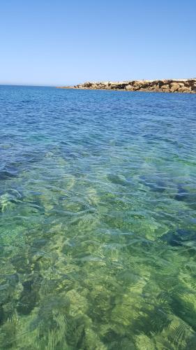 a large body of water with rocks in the background at A Due Passi Dal Mare in Petrosino