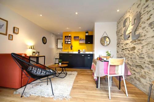 ein Wohnzimmer mit einem Tisch und Stühlen sowie eine Küche in der Unterkunft Le 22 grand rue in Rezé