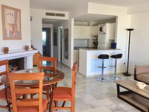 Una cocina y una sala de estar con mesa y sillas. en Puerto Marina, en Benalmádena