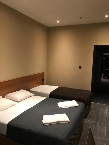 two beds in a room with towels on them at Royal Hotel in Brussels