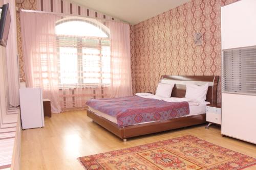 ein Schlafzimmer mit einem Bett und einem großen Fenster in der Unterkunft Ivy Boutique Hotel in Yerevan