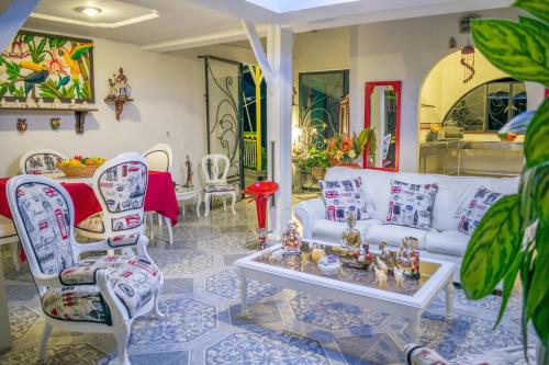 a living room with a white couch and chairs at Finca Azulinas in La Tebaida