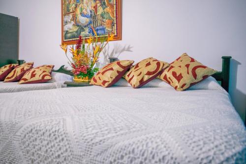 two beds with pillows and a painting on the wall at Finca Azulinas in La Tebaida