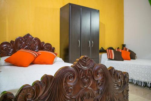 a bedroom with two beds with orange pillows at Finca Azulinas in La Tebaida