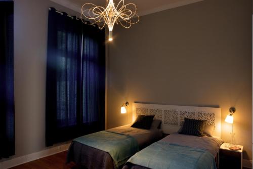 a bedroom with two beds and a chandelier at City-Apartment Reger Privatparkplatz in Krefeld