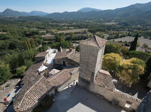 an aerial view of a building with mountains in the background at Logis Hôtel Les Hospitaliers in Le Poët-Laval