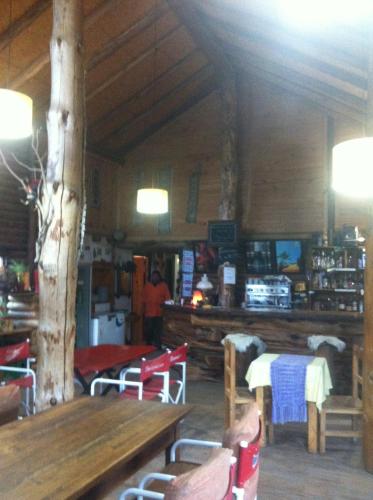 a restaurant with a wooden table and chairs in a room at Hostería de Montaña los Duendes del Volcán in Caviahue