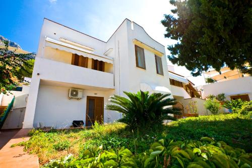 a white house with a tree in front of it at Hotel Pocho in San Vito lo Capo