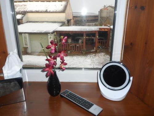 a table with a vase of flowers and a remote control at Midtown Farm Bed & Breakfast in Easton