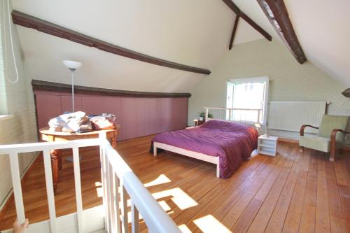 Schlafzimmer mit einem Bett und Holzboden in der Unterkunft La maison du fond du jardin in Brüssel