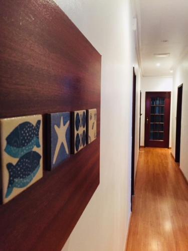 a hallway with paintings of fish on a wall at Garden Guest House in Lisbon
