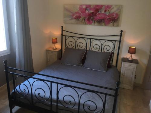 a black bed with two night stands and two lamps at La maison de Salavas in Vallon-Pont-dʼArc