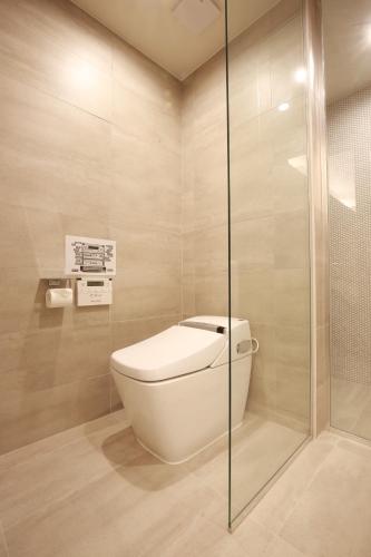 a bathroom with a toilet and a glass shower at Hotel East9 in Gangneung