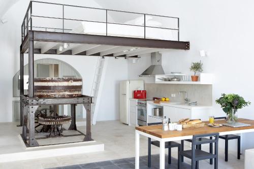a kitchen with a loft bed in the middle of a room at Villa Fabrica Santorini in Pyrgos