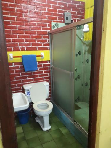 a bathroom with a toilet and a glass shower at Hotel Casa Del Viajero in Quetzaltenango