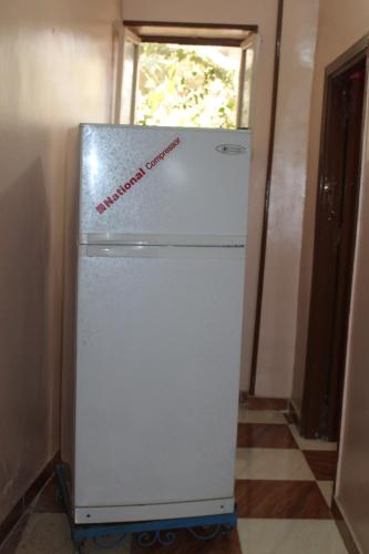 a white refrigerator with a sign on it in a room at Hamo Guest House in Aswan