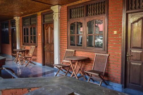 un grupo de sillas y mesas en un porche en Puri Agung Homestay en Kuta