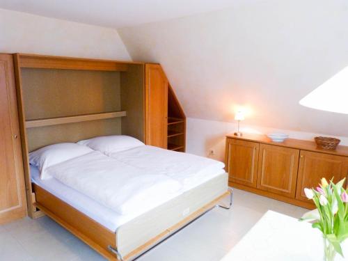 a bedroom with a bed and a cabinet and a table at Haus *Üüs Aran* Wohnung Nr. 7 in Nebel
