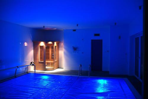 an empty swimming pool in a room with blue lights at Penzion Patriot in Výprachtice