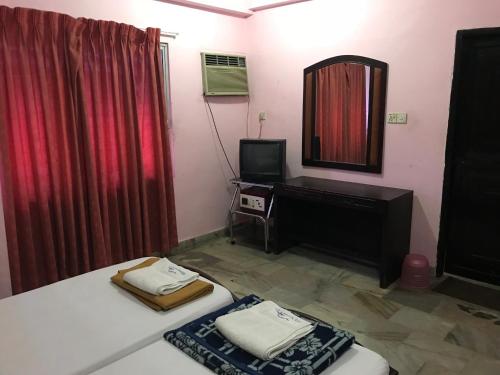 Habitación con espejo, cama y espejo. en Indraprastham Tourist Home, en Kottayam