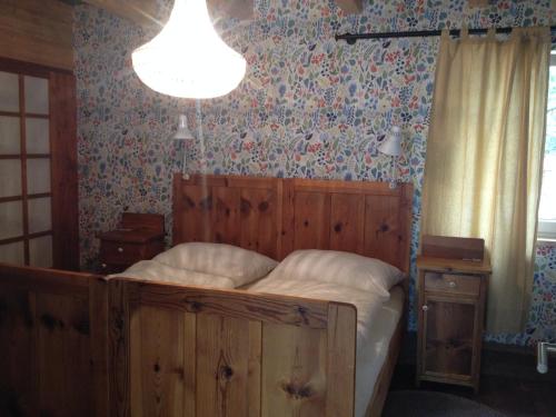 a bedroom with a bed with a wooden headboard and floral wallpaper at Südalpen Lofts in Bleiburg