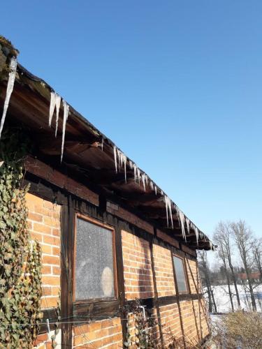 an old brick house with icicles on the roof at Familienhof Müritz in Klein Plasten