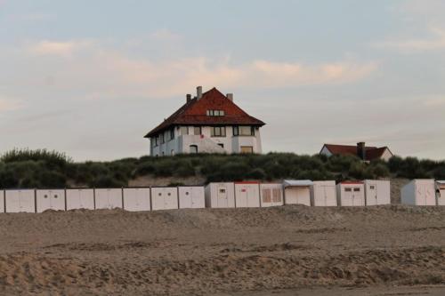 a house on top of a hill with a fence at Prinses Elisabeth in Koksijde