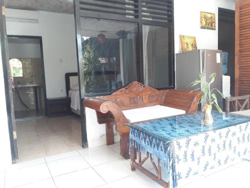 a living room with a wooden bench and a table at G Saskara Homestay in Sanur