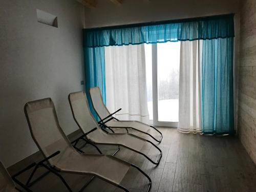 three chairs sitting in a room with a window at Rifugio Pranolz in Trichiana