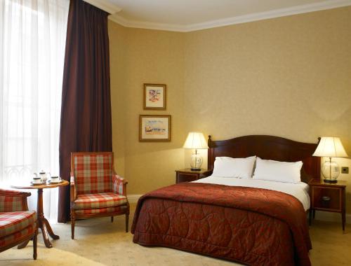 a hotel room with a bed and a chair at The Imperial Torquay in Torquay