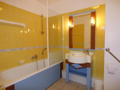 une salle de bain avec un lavabo, une baignoire et un miroir dans l'établissement Appartement T2 Residence Le Club, à Talmont-Saint-Hilaire