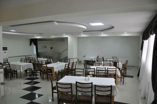 a dining room with white tables and chairs at Hotel Kavkasioni in Kvareli