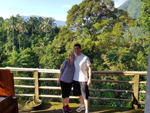 a man and a woman standing in front of a mountain at Sugi Gede Homestay in Singaraja