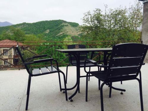 a table and chairs on a balcony with a view at Hotel Kavkasioni in Kvareli
