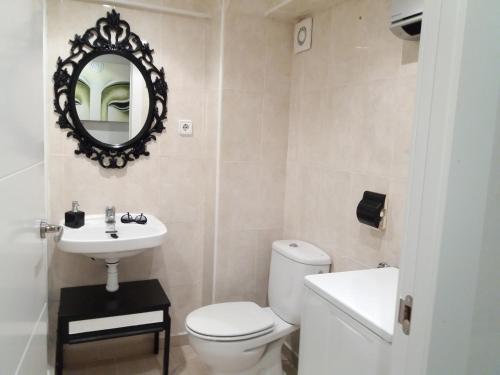 a bathroom with a toilet and a sink and a mirror at Apartamento Torre Sant Salvador in Comarruga