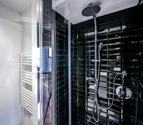 een badkamer met een douche en zwart betegelde muren bij Dreamy Brunelleschi in Florence
