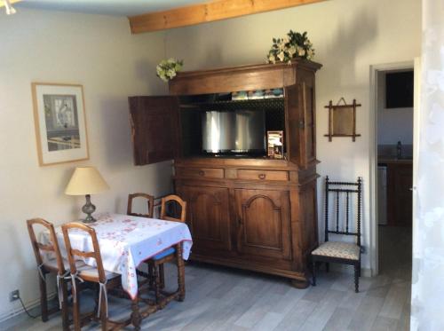 d'une salle à manger avec une table et une armoire en bois. dans l'établissement Studio Montfleury, à Corenc