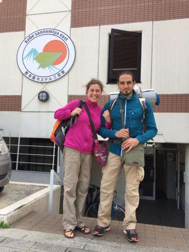 a man and a woman standing in front of a building at T and K Hostel Kobe Sannomiya East in Kobe