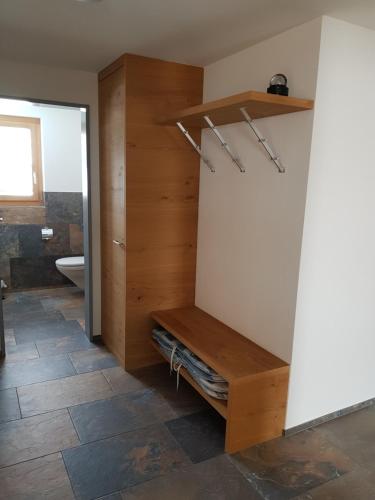 a bathroom with a wooden shelf and a toilet at Ferienwohnung Allmeina in Malbun
