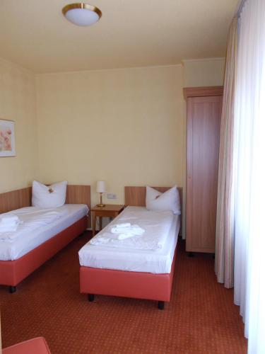 a hotel room with two beds and a window at Berg-Gasthof Honigbrunnen in Löbau