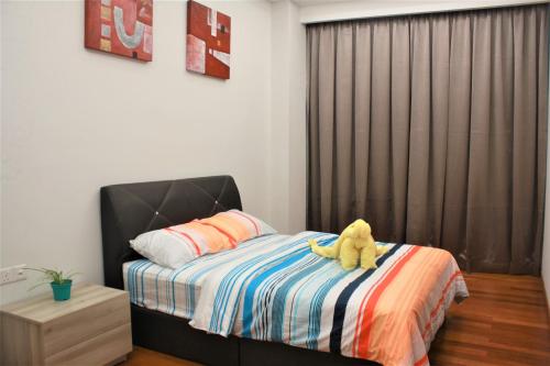 a teddy bear sitting on a bed in a bedroom at Azure Residence Paradigm Mall in Petaling Jaya