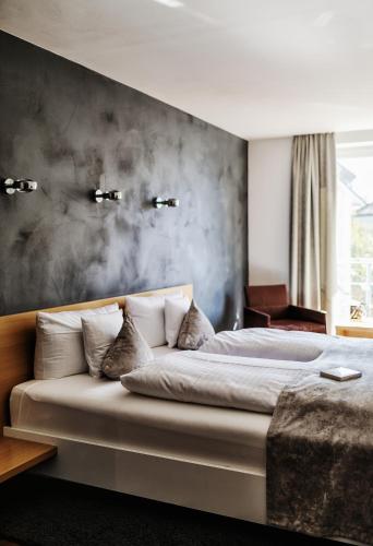 a bedroom with a large bed with a wall at Seevital Hotel & SPA - Ihr 4 Sterne Superior Hideaway direkt am See in Langenargen
