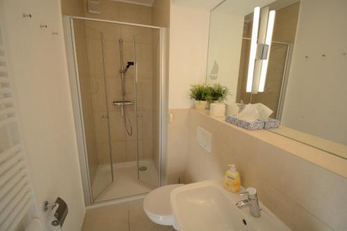 ein Bad mit einer Dusche, einem WC und einem Waschbecken in der Unterkunft Haus Lackner in Timmendorfer Strand